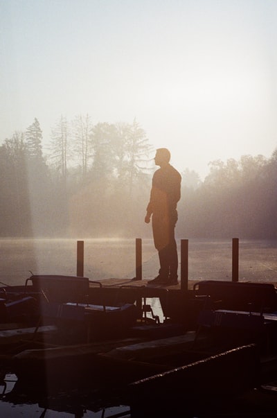 白天站在木码头上的男人的剪影